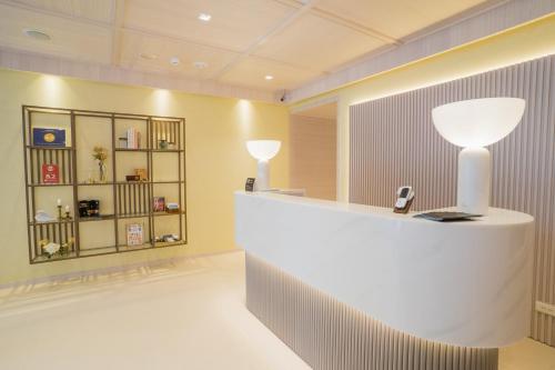 a lobby with a reception counter with a lamp at Royal Rose Hotel Taipei Station in Taipei