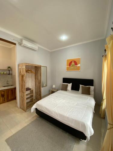 1 dormitorio con 1 cama blanca grande. en LaGriya Guest House, en Ketewel