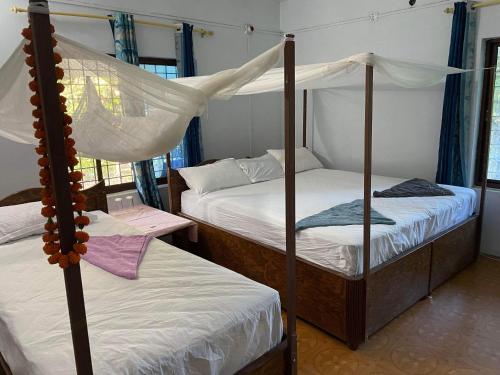 - une chambre avec 2 lits superposés et une table dans l'établissement Good Karma Homestay, à Bhurkīā