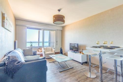 un salon avec un canapé et une table dans l'établissement La Vue Marine - Appartement vue mer, à Courseulles-sur-Mer