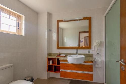 bagno con lavandino e specchio di Sahaj Holiday Apartments a Baie Sainte Anne