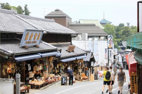 a street with people walking in front of shops at Richmond Hotel Narita in Narita