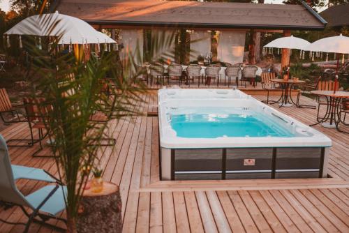 a hot tub on a deck with tables and chairs at Woodstock B & B Studios in Bålsta