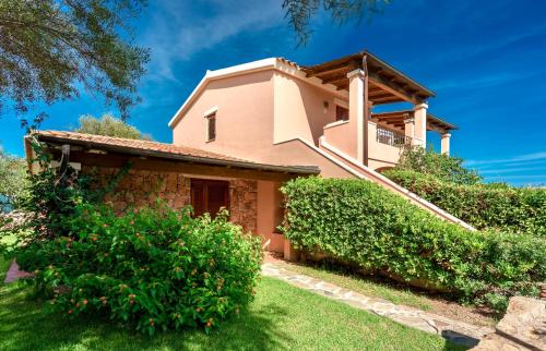 uma villa com um jardim em frente a uma casa em ISA-apartments with air conditioning and private outdoor space in San Teodoro em San Teodoro