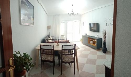 een woonkamer met een tafel en stoelen en een televisie bij R Y M 1950 Apartamento in Avilés
