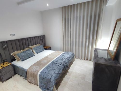 een slaapkamer met een bed en een raam met gordijnen bij roof top duplex with solarium in Bouznika