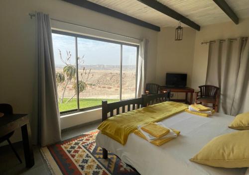 a bedroom with a bed and a large window at Moon Landscape Self Catering in Swakopmund