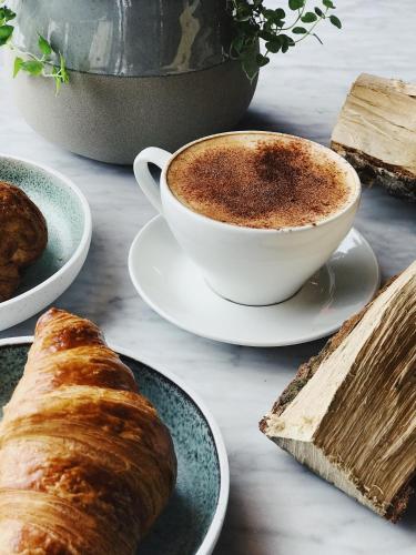 a cup of coffee and a loaf of bread on a table at Ciauru Design B&B in Messina