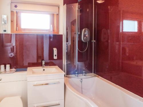 a bathroom with a tub and a sink and a shower at Burnside Lodge in Fort William