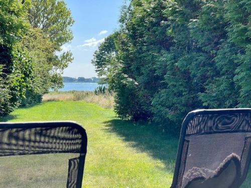 a bench sitting in the grass next to a body of water at Pia´s Guesthouse in Askeby