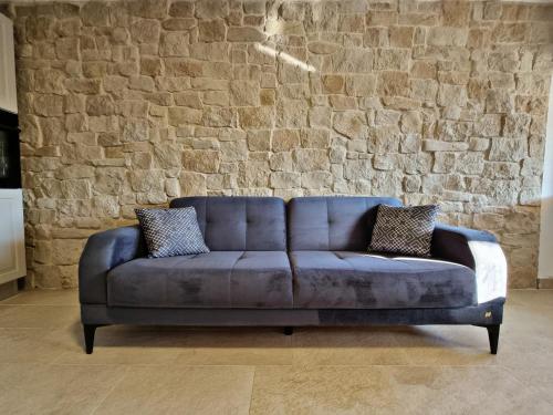 a blue couch in a room with a brick wall at Holiday home Barci in Crikvenica