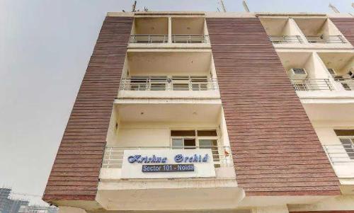 un bâtiment avec un panneau sur son côté dans l'établissement OYO Krishna Orchid Near Noida Sector 81 Metro Station, à Noida