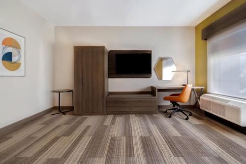 a room with a desk and a television and a chair at Holiday Inn Express & Suites - Glendale Downtown in Glendale