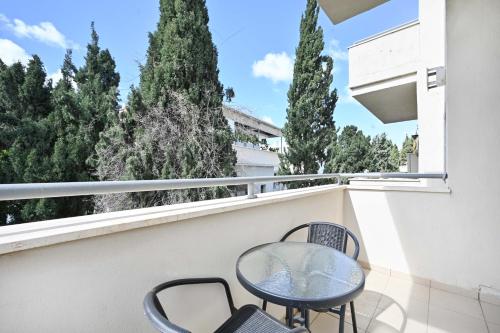een tafel en stoelen op een balkon met bomen bij Perfect Location 2BR in Reines by HolyGuest in Tel Aviv