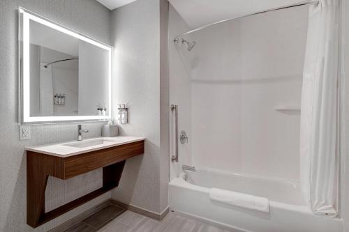 a bathroom with a sink and a tub and a shower at Holiday Inn Express & Suites - Glendale Downtown in Glendale