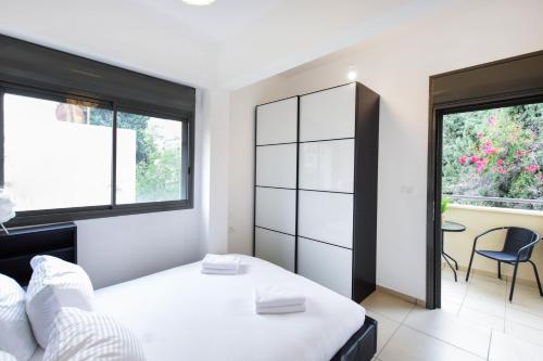 een slaapkamer met een wit bed en een raam bij Perfect Location 2BR in Reines by HolyGuest in Tel Aviv