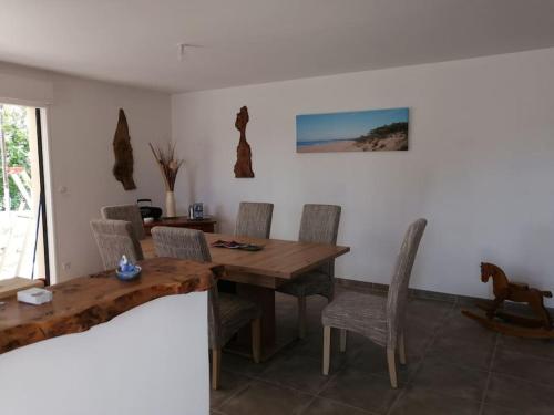 une salle à manger avec une table et des chaises en bois dans l'établissement Maison proche de Royan à Meschers sur Gironde 2 chambres, à Meschers-sur-Gironde