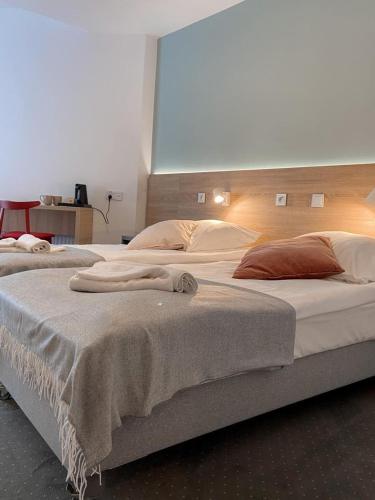 2 Betten in einem Hotelzimmer mit Handtüchern darauf in der Unterkunft Ośrodek Tulipan in Ustroń