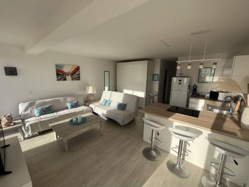 Il comprend un grand salon avec un canapé et une cuisine. dans l'établissement Appartement face à la mer, à Saint Pierre La Mer