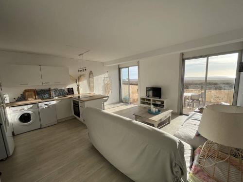 un salon avec un canapé et une cuisine dans l'établissement Appartement face à la mer, à Saint Pierre La Mer