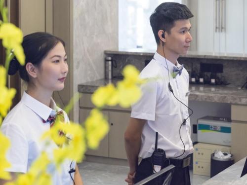 a man and a woman in a kitchen with a headset at GreenTree Eastern Hotel Hainan Free Trade Port Jiangdong New District Meilan Airport in Haikou