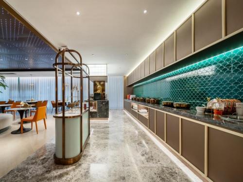 a kitchen with a table and a dining room at GreenTree Eastern Hotel Nanjing Jiangning University in Jiangning