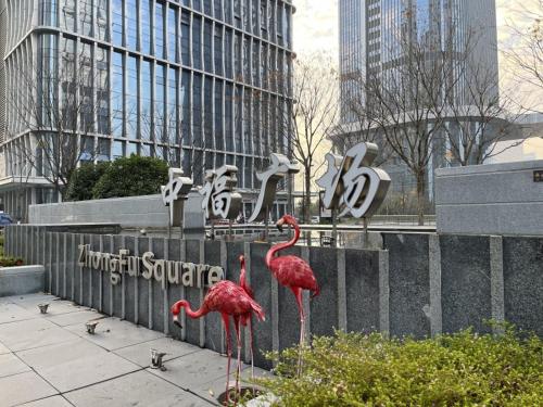 two flamingos standing in front of a sign with buildings at GreenTree Eastern Hotel Yiwu International Trade City in Yiwu