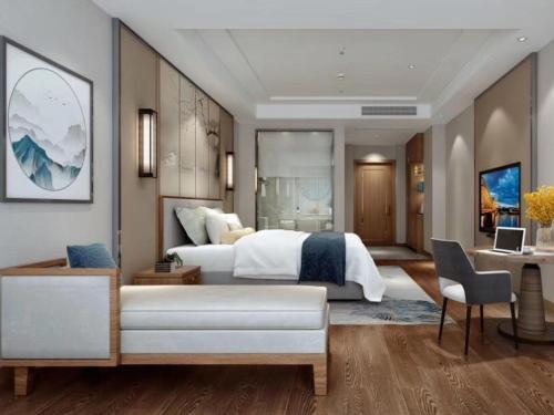 a bedroom with a large white bed and a desk at GreenTree Eastern Hotel Hainan Free Trade Port Jiangdong New District Meilan Airport in Haikou