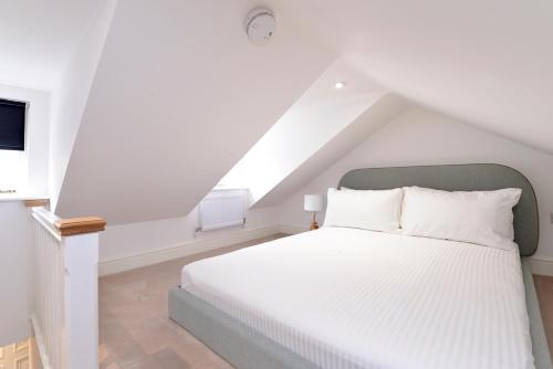a bedroom with a white bed in a attic at 1 bedroom flat in centre of Odiham- free parking in Odiham