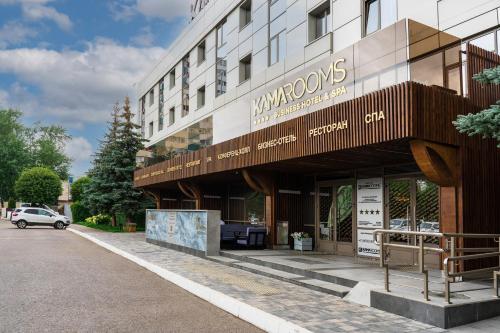 un edificio con un cartel en el costado en Kamarooms Business Hotel & Spa, en Naberezhnye Chelny