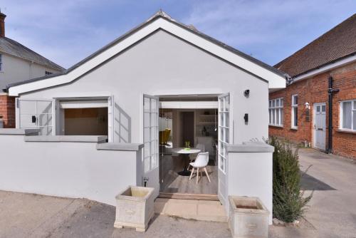 a white house with a door leading into a courtyard at 1 bedroom flat in centre of Odiham- free parking in Odiham