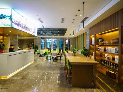 重慶市にあるGreenTree Eastern Hotel Chongqing Jiefangbei Children's Hospitalのバー、テーブル、椅子が備わるレストラン