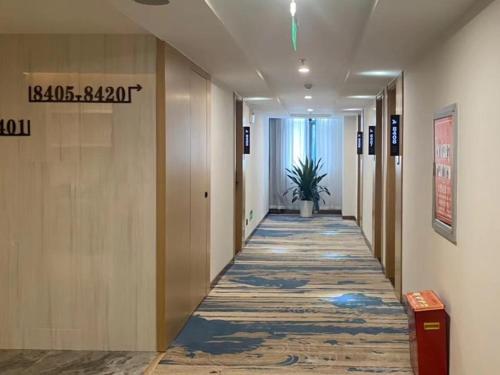a hallway of an office with a plant in the distance at GreenTree Eastern Hotel Huai'an Suning Plaza West Huaihai Road in Huai'an