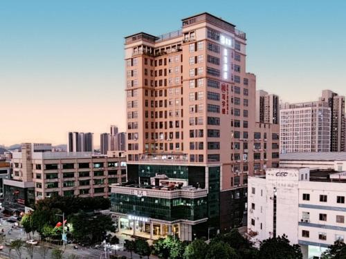 a tall building in a city with many buildings at GreenTree Eastern Hotel Shenzhen Pinghu Hua'nan City Hehua Subway Station in Longgang