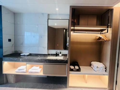 a bathroom with a sink and a mirror at GreenTree Eastern Hotel Wuhan Optics Valley East Lake Wuhan University in Wuhan