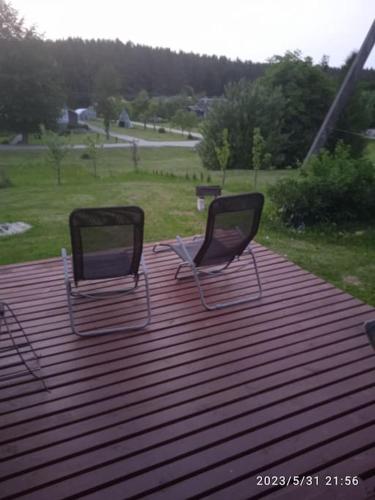 duas cadeiras sentadas no topo de um telhado em Viešnagė name prie miško. em Magučiai