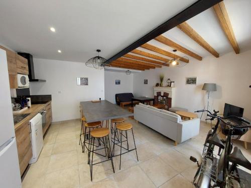 une cuisine et un salon avec une table et des chaises dans l'établissement Maison plein centre COULON MARAIS POITEVIN, à Coulon