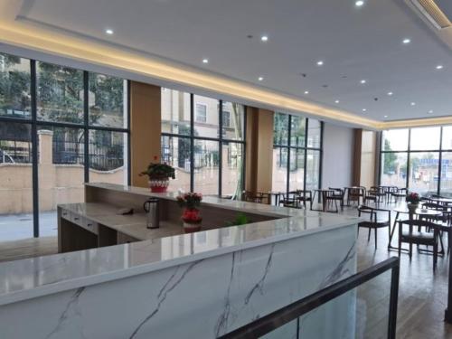 a large lobby with tables and chairs and windows at GreenTree Eastern Hotel Tongling Yi'an Government in Xihu