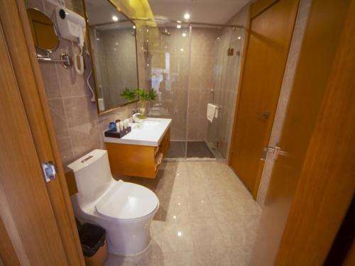 a bathroom with a toilet and a sink and a shower at GreenTree Eastern Hotel Hebi Jun County Passenger Station in Xun