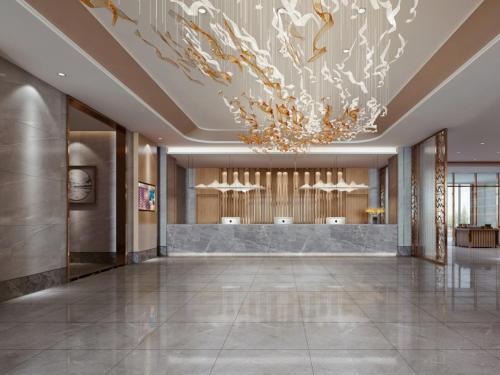a lobby with a large chandelier in a building at GreenTree Eastern Hotel Hainan Free Trade Port Jiangdong New District Meilan Airport in Haikou