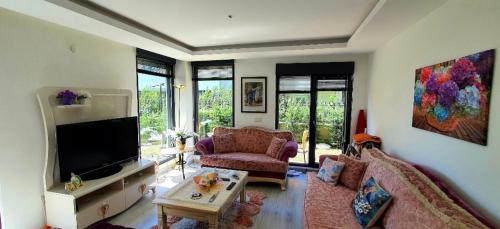 ein Wohnzimmer mit einem Sofa und einem Flachbild-TV in der Unterkunft Albatros in Büyükçekmece