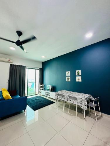 een woonkamer met een tafel en een blauwe muur bij Bella Homestay by AK Group in Cyberjaya