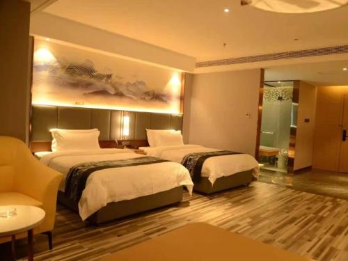 a hotel room with two beds and a couch at GreenTree Eastern Hotel Dezhou Qingyun Yingcai Road Financial Building in Dezhou