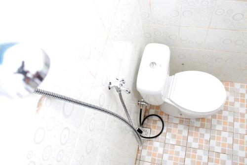 a bathroom with a white toilet in a room at Liahz Lodge in Kelimutu