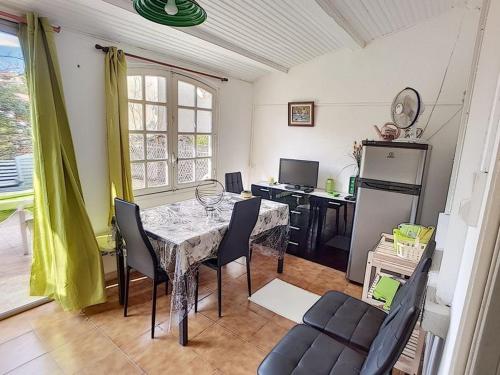 une salle à manger avec une table et des chaises et une cuisine dans l'établissement Appartement avec accès direct à la plage, à Saint Pierre La Mer