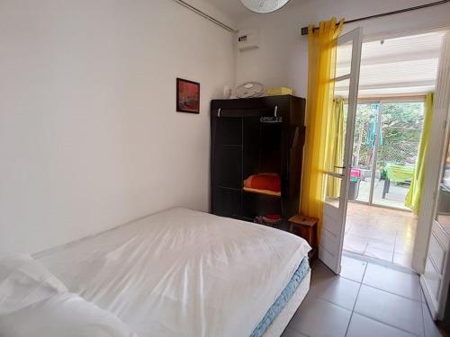 une chambre avec un lit blanc et une fenêtre dans l'établissement Appartement avec accès direct à la plage, à Saint Pierre La Mer