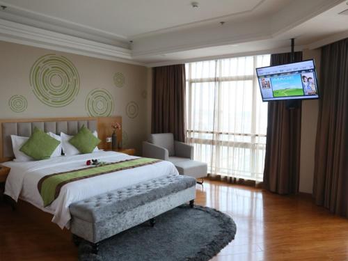 a bedroom with a large bed and a flat screen tv at GreenTree Inn Suqian Yanghe Xuhuai Road in Suqian