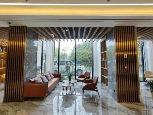 a living room with a couch and a table and chairs at GreenTree Eastern Hotel Huai'an Suning Plaza West Huaihai Road in Huai'an