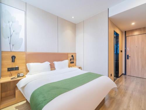 Ένα ή περισσότερα κρεβάτια σε δωμάτιο στο GreenTree Inn Express Hotel Tongcheng Xindu North Xin'an Road
