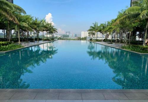 a large pool of blue water with palm trees at Bella Homestay by AK Group in Cyberjaya